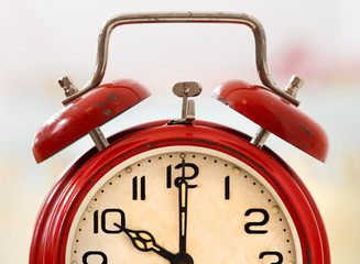 Time concept - old red retro alarm clock close-up