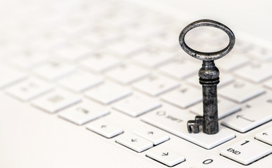 Key standing on a white laptop - web banner of business success and solution concept