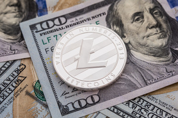 Silver Litecoin coin on dollars banknotes background. Business and Technology concept. Digital currency physical metal litecoin coin - Virtual cash concept.