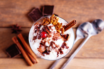 Ice cream sundae, spices, chocolate pieces and spoons