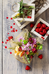 Background Valentine's Day or wedding. Basket bouquet of roses and chrysanthemums on a vintage wooden background. Flat lay.