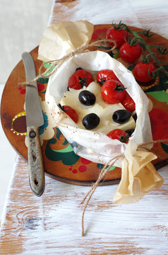gebackener Feta mit Tomaten, Oliven und Zwiebeln im Pergamentpapier