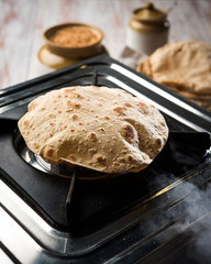 indian bread / Chapati / Fulka / Gehu Roti with wheat grains in background. It's a Healthy fiber rich traditional North/South Indian food, selective focus   © StockImageFactory
