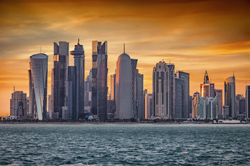 Obraz premium Das moderne Zentrum mit zahlreichen Wolkenkratzern in Doha, Katar, bei Sonnenuntergang