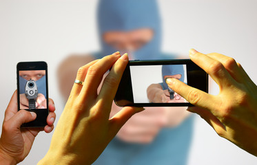 Gaffer fotografieren mit Handys einen Bankräuber mit Pistole