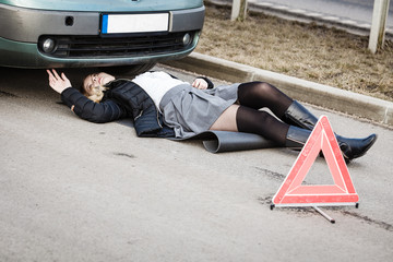Woman, repairing broken car lying under it