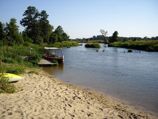 Łódka na brzegu rzeki zacumowana przy pomoście © Monika