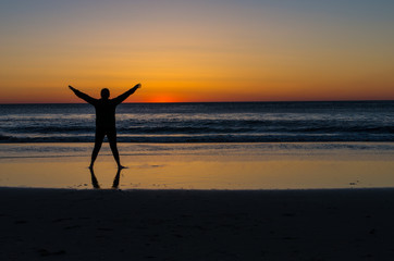 young woman watching the sunrise over the ocean