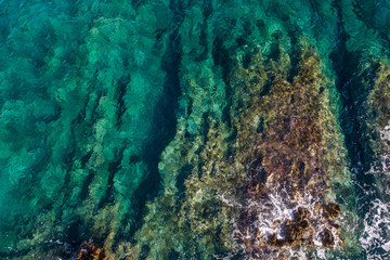 Aerial view of the green waves that beat the sea cliffs