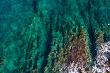 Aerial view of the green waves that beat the sea cliffs