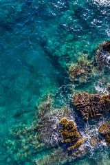 Aerial view of the green waves that beat the sea cliffs
