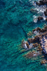 Aerial view of the green waves that beat the sea cliffs
