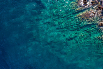 Aerial view of the green waves that beat the sea cliffs