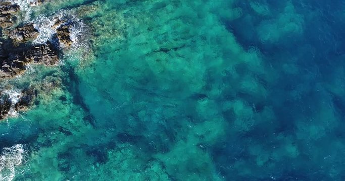 Aerial view. Flight over the green waves that beat the rocks in Montenegro