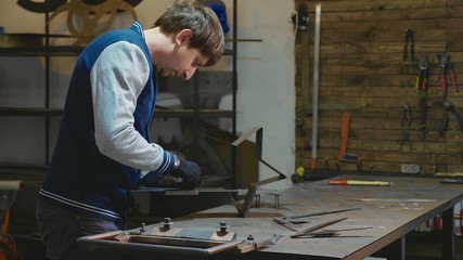 Blacksmith working with metal decorative detail at his workshop