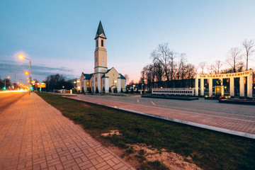 Evening time in the city with a church and a monument to soldier