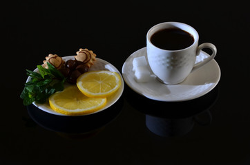 White turkish cup of coffee with sugar, orange on black table