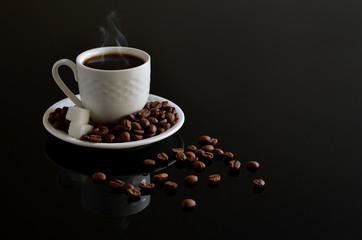 Hot Coffee cup with Coffee beans on the black table