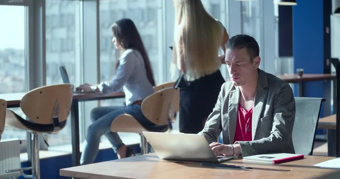 Creative modern office 4k video. People working over computer laptop screen. Business team at workplaces. Company staff in open space. Woman and man