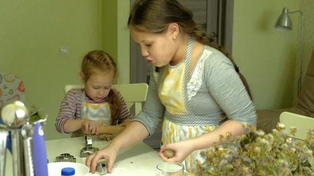 Two kids kneading the dough for make cookies together