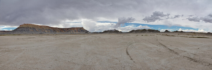 panoramic view of desert with Factory Butte and  Cainville reef rising above moon like badlands 
Hanksville, Wayne County, Utah, USA