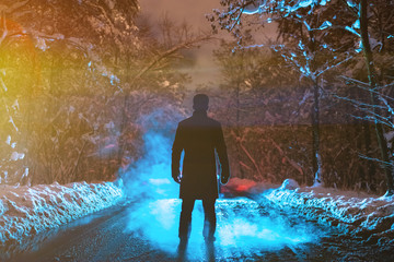 The man stand on a forest road on the smoke background. evening night time