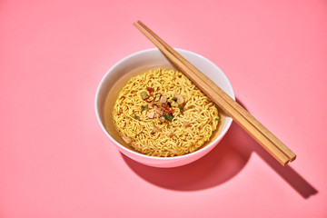 A Bowl of instant noodles on pink background