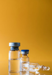 Medicine in vials , ready for vaccine injection isolated on orange background