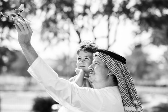 Arabic father and little kid play outdoors.Black and white.