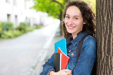 Portrait of a young student with backpack going to school and holding notebook - Back to school