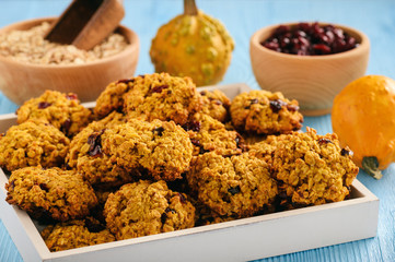 Pumpkin oatmeal cookies with cranberries on blue wooden background.