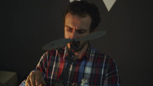 engineer repair drone, man work with quadrocopter in dark studio 