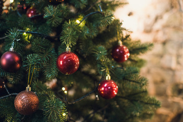 Christmas tree with garlands on a brick wall background
