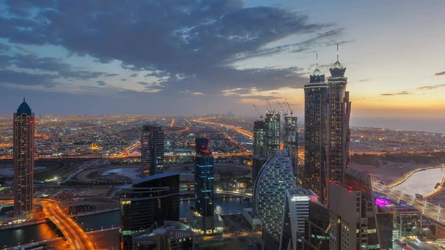 Nighttime skyline of a big modern city. Scenic aerial view of downtown Dubai, UAE with skyscrapers and highways. 4K time lapse