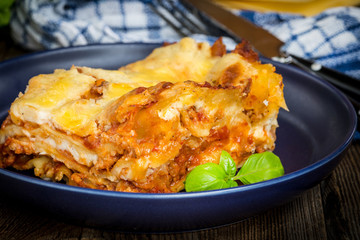 Piece of tasty hot lasagna with red wine.