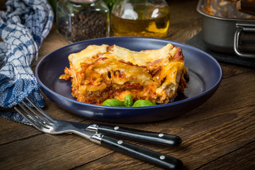 Piece of tasty hot lasagna with red wine.