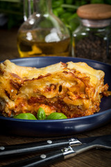 Piece of tasty hot lasagna with red wine.