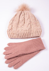 Wool hat and gloves for winter weather on a white background.