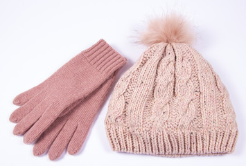 Wool hat and gloves for winter weather on a white background.