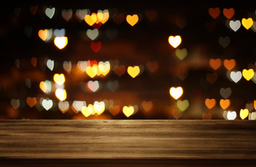 Empty rustic table in front of Valentine's day romantic glitter bokeh background with many hearts...