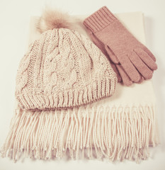 Warm winter knitted clothes - hat, scarf, gloves on a white background.