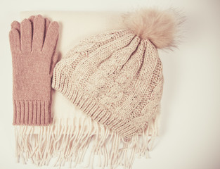 Warm winter knitted clothes - hat, scarf, gloves on a white background.