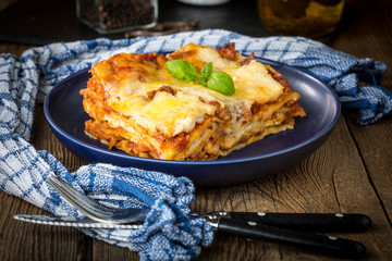 Piece of tasty hot lasagna with red wine.