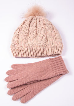 Wool hat and gloves for winter weather on a white background.
