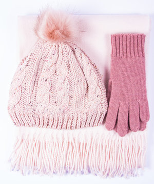 Warm winter knitted clothes - hat, scarf, gloves on a white background.
