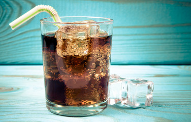 Sweet, fizzy drink with ice on a blue background.
