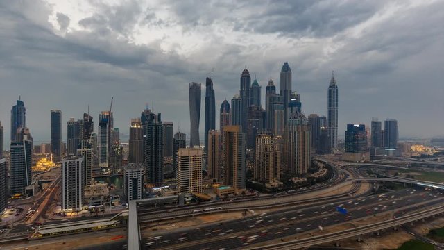 Fantastic skyline of Dubai Marina by night. Scenic elevated view over skyscrapers and highways. 4K day to night transition time lapse. 