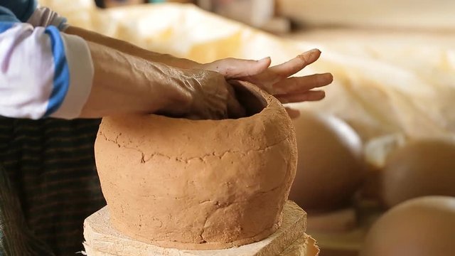 Potter at work. Close-up of woman making ceramic pot on the pottery wheel
