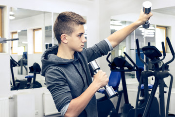 The teenager is engaged in power fitness in the gym.