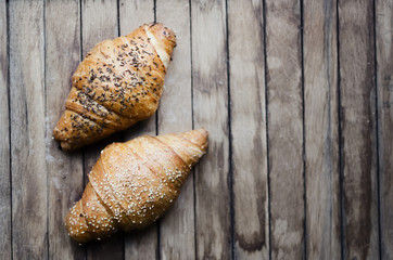 Fresh croissant on a wooden retro background. Top view